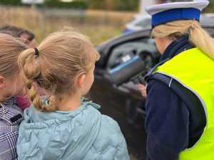 Zdjęcie policjantki oraz dzieci w trakcie kontroli drogowej.