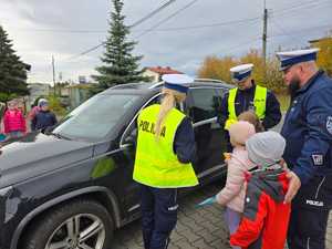 Zdjęcie policjantów oraz dzieci w trakcie kontroli drogowej.