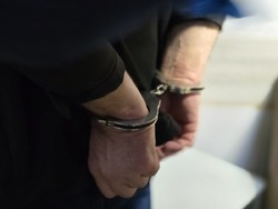 Zdjęcie założonych kajdanek na rękach.