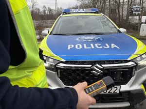 Zdjęcie policjanta trzymającego urządzenie do badania stanu trzeźwości.
