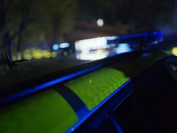 Zdjęcie radiowozu z włączonym światłem pojazdu uprzywilejowanego.