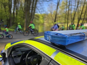 Radiowóz oraz uczestnicy rajdu.