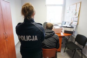 Policjantka nadzorująca przebieg przesłuchania zatrzymanego mężczyzny