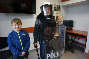 Chłopcy ze swoim tatą ubranym w strój policjanta prewencji