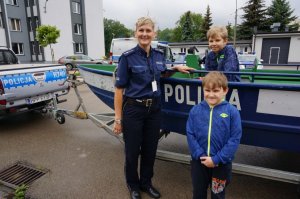 Dzieci z panią policjantką przy łodzi motorowej