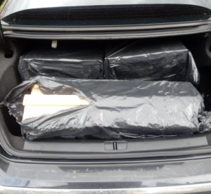 Otwarty bagażnik samochodu a w środku kartony z papierosami
