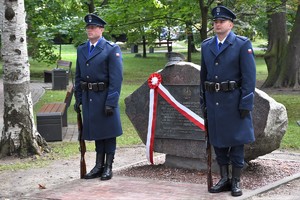 Zdjęcie. Widoczna policyjna warta honorowa przed obeliskiem