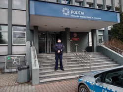 na zdjęciu umundurowany policjant stojący przed budynkiem Komendy Miejskiej Policji w Jaworznie