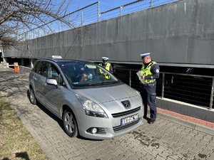 na zdjęciu policjanci stoją przy taksówce