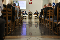 na zdjęciu prelegenci siedzący na krzesłach