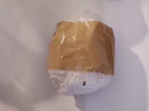 na zdjęciu biała kulka przypominająca narkotyki zawinięta w folię
