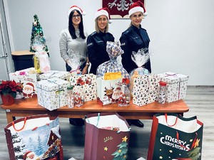 na zdjęciu dwie policjantki i kobieta, które stoją przy stole z prezentami