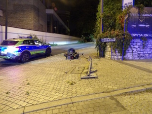 na zdjęciu widać przewrócony motocykl oraz oznakowany radiowóz policji