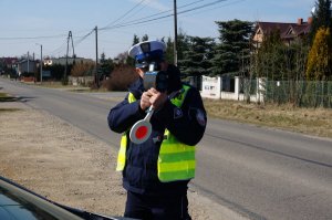 Policjant mierzy prędkość laserowym miernikiem.