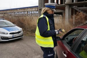 Policjantka sprawdza stan trzeźwości kierującego.