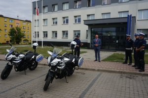 komendant, starosta, policjanci oraz dwa motocykle policyjne przed komendą