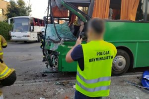 technik kryminalistyki fotografuje uszkodzony autobus