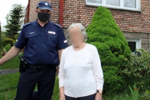 umundurowany policjant stoi  obok starszej kobiety