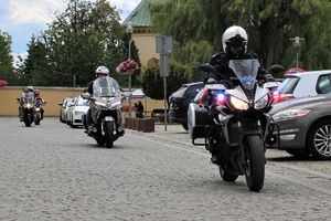 policjant ruchu drogowego jedzie na motorze, za nim inne motocykle
