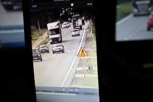 ekran, na którym widać samochód wyprzedzający inny samochód na przejściu dla pieszych
