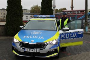 Zdjęcie przedstawia policjanta ruchu drogowego oraz nowy policyjny radiowóz.