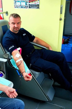 Zdjęcie przedstawia policjanta, który oddaje krew.