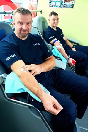 Zdjęcie przedstawia dwóch policjantów, którzy oddają krew.