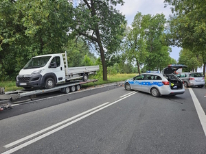 Zdjęcie przedstawia miejsce wypadku drogowego oraz radiowóz, rozbite auto i wóz strażacki.
