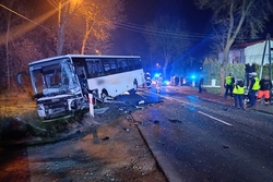 Zdjęcie przedstawia rozbity autobus, policjantów oraz radiowóz.