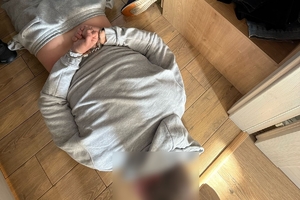 Zdjęcie przedstawia mężczyznę w kajdankach leżącego na podłodze.