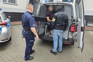 Zdjęcie przedstawia policjantów oraz zatrzymanego w radiowozie.