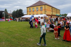 Zdjęcie przedstawia policjantkę, Sznupka oraz uczestników pikniku.