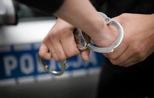 Zdjęcie przedstawia kajdanki na dłoniach.