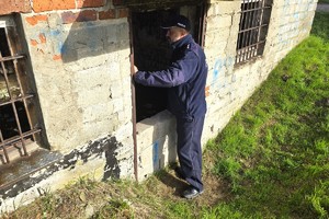 Policjant sprawdza wnętrze zniszczonego budynku w poszukiwaniu osób potrzebujących pomocy.