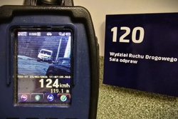 ekran miernika prędkości, pojazd oraz wskazana prędkość 124 kilometry na godzinę