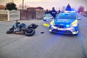 przewrócony motocykl, z tyłu oznakowany radiowóz