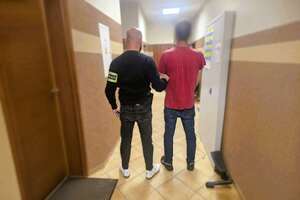 policjant prowadzi zatrzymanego
