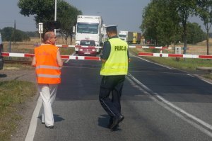 policjant i pracownik koleii przed przejazdem