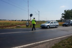 policjant wręcza kierowcy ulotkę