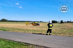 Na zdjęciu strażak i śmigłowiec lotniczego pogotowia ratunkowego.