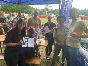 na zdjęciu widoczni są ludzie którzy trzymają krzyżówkę w dłoniach