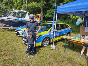 na zdjęciu widoczny jest policjant z chłopcem przebranym za policjanta