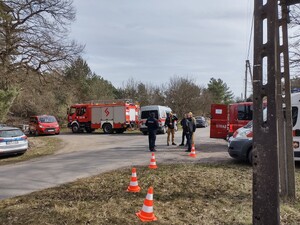 skrzyżowanie dróg wozy strażackie radiowóz widoczni są umundurowani funkcjonariusze