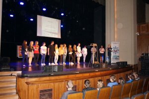 Szkolna grupa teatralna na scenie po zakończeniu przedstawienia