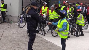 Policjantka rozdaje uczestnikom rajdu odblaski