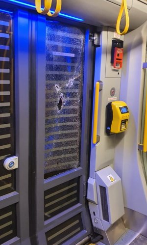 zdjęcie kolorowe: uszkodzona szyba w rozsuwanych drzwiach tramwaju