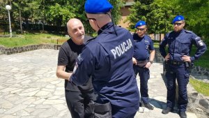 zdjęcie kolorowe: spotkanie ojca rannego motocyklisty z polskimi policjantami na placu przed szpitalem