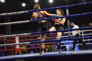 zdjęcie kolorowe: Justyna Ciborska w ringu zadająca cios nogą Paulinie Badowskiej