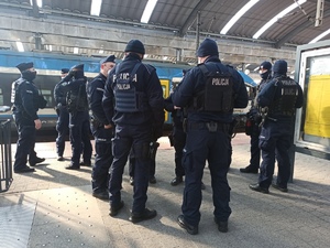 zdjęcie kolorowe: policjanci katowickiego oddziału prewencji oczekujący na przyjazd pociągu z uchodźcami