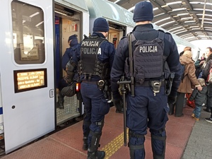 zdjęcie kolorowe: policjanci katowickiego oddziału prewencji wsiadający do pociągu z uchodzcami